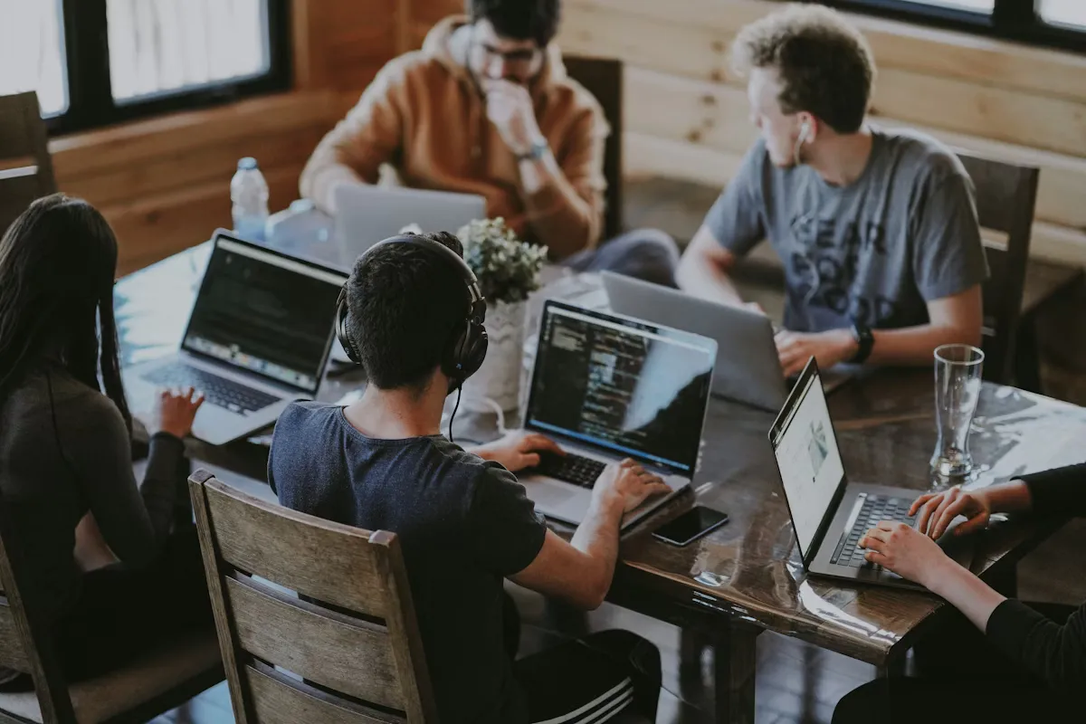 Team collaborating together around a laptop in an office
